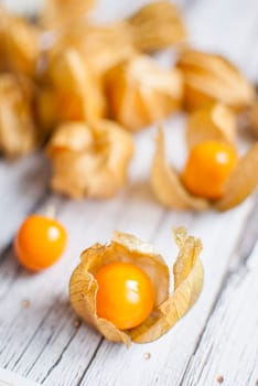 ripe healthy orange physalis over wooden board