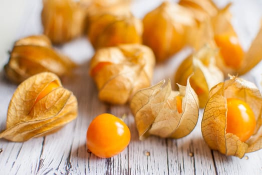 ripe healthy orange physalis over wooden board