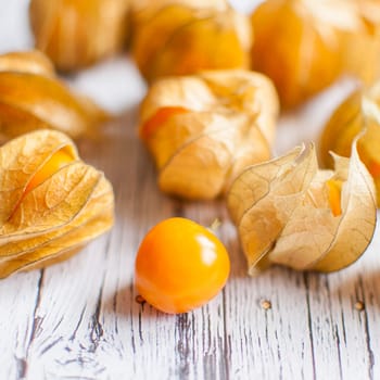 ripe healthy orange physalis over wooden board