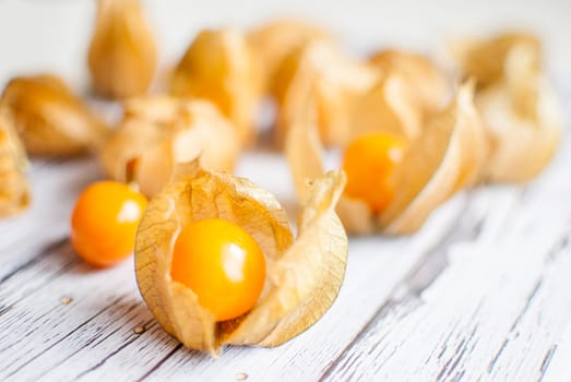 ripe healthy orange physalis over wooden board