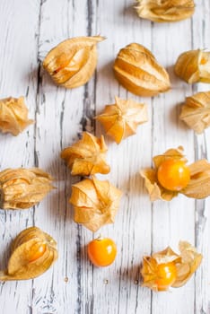 ripe healthy orange physalis over wooden board