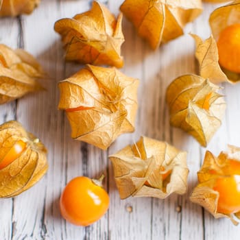 ripe healthy orange physalis over wooden board