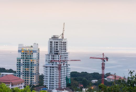 buildings under construction and cranes and the sea