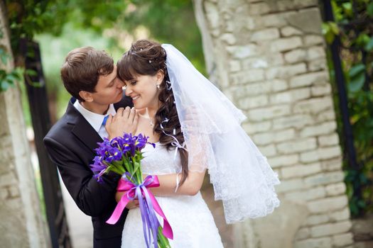 bride and groom by the wall 