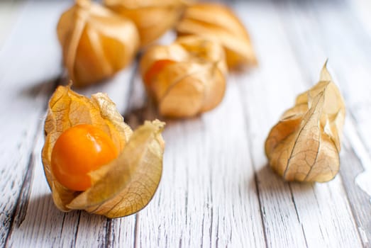 ripe healthy orange physalis over wooden board