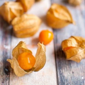 ripe healthy orange physalis over wooden board