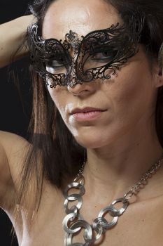 Beautiful young woman in mysterious black Venetian mask. Fashion photo. tribal design.