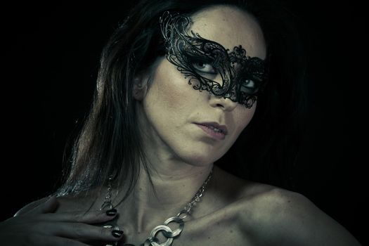 Beautiful young woman in mysterious black Venetian mask. Fashion photo. tribal design.