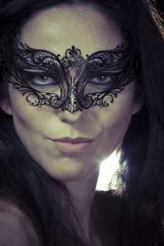 Beautiful young woman in mysterious black Venetian mask. Fashion photo. tribal design.