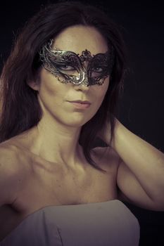 Style.Beautiful young woman in mysterious black Venetian mask. Fashion photo. tribal design.