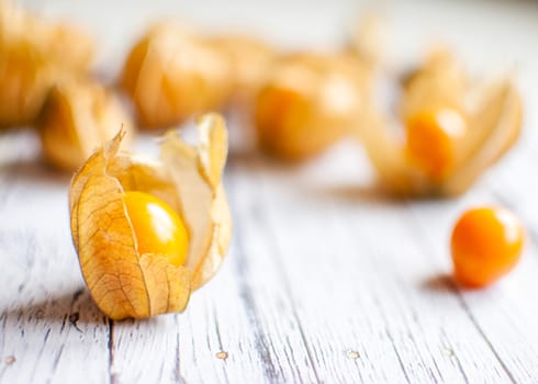 ripe healthy orange physalis over wooden board