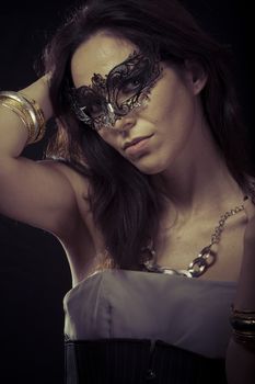 Beautiful young woman in mysterious black Venetian mask. Fashion photo. tribal design.