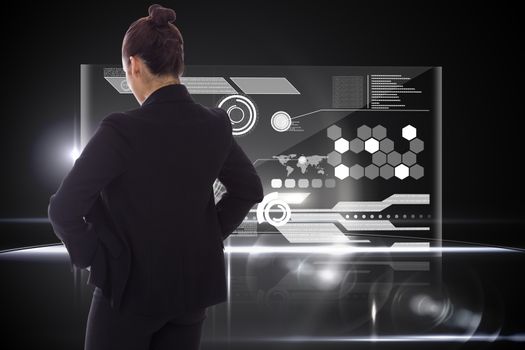 Businesswoman with hands on hips against technology interface