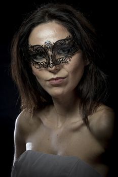Style.Beautiful young woman in mysterious black Venetian mask. Fashion photo. tribal design.