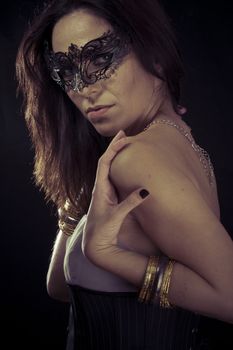 Vintage.Beautiful young woman in mysterious black Venetian mask. Fashion photo. tribal design.