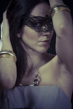 Costume.Beautiful young woman in mysterious black Venetian mask. Fashion photo. tribal design.