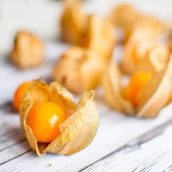 ripe healthy orange physalis over wooden board