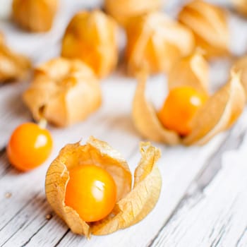 ripe healthy orange physalis over wooden board