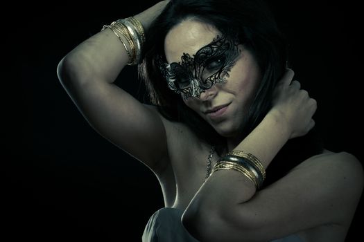 Tribal.Beautiful young woman in mysterious black Venetian mask. Fashion photo. tribal design.