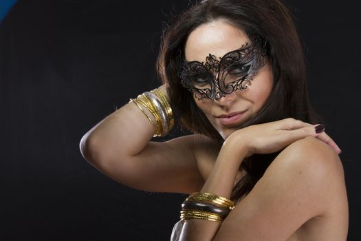 Sensuality.Beautiful young woman in mysterious black Venetian mask. Fashion photo. tribal design.