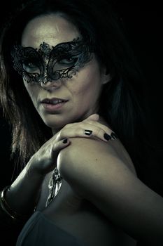 Beautiful young woman in mysterious black Venetian mask. Fashion photo. tribal design.