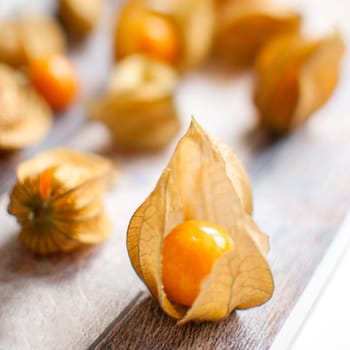 ripe healthy orange physalis over wooden board