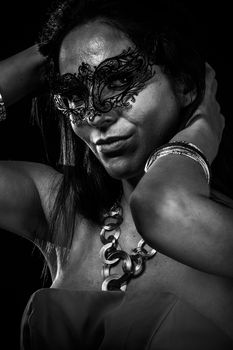 Beautiful young woman in mysterious black Venetian mask. Fashion photo. tribal design.