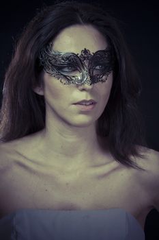 Beautiful young woman in mysterious black Venetian mask. Fashion photo. tribal design.