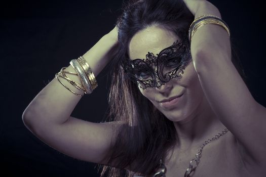 Tribal.Beautiful young woman in mysterious black Venetian mask. Fashion photo. tribal design.