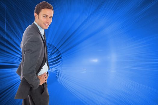 Cheerful businessman standing with hands on hips against global technology background