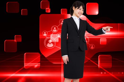 Smiling businesswoman pointing against futuristic technology interface