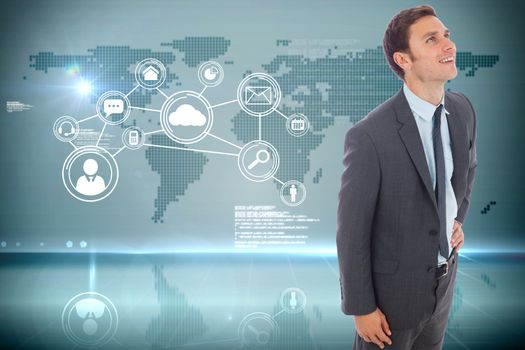 Cheerful businessman standing with hand on hip against futuristic technology interface
