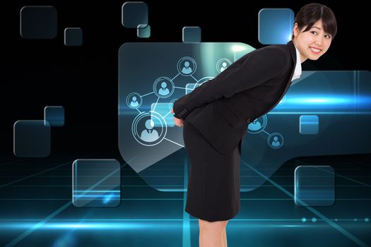 Smiling businesswoman bending against futuristic technology interface