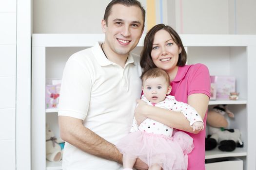 Happy family at home mother and father holding their young ballet dancer
