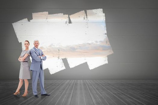 Serious businessman standing back to back with a woman  against display on wall showing bright sky