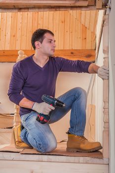 worker sitting and holding cordless drill