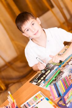 Boy colouring book looking at camera angled