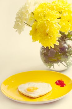 Breakfast. Fried eggs in a heart-shaped bouquet of chrysanthemums near