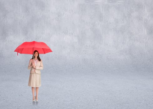 Attractive businesswoman holding red umbrella against grey wall