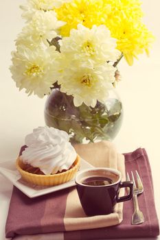 Coffee and cake with whipped cream near chrysanthemums