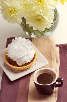 Coffee and cake with whipped cream near chrysanthemums