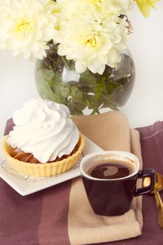 Coffee and cake with whipped cream near chrysanthemums