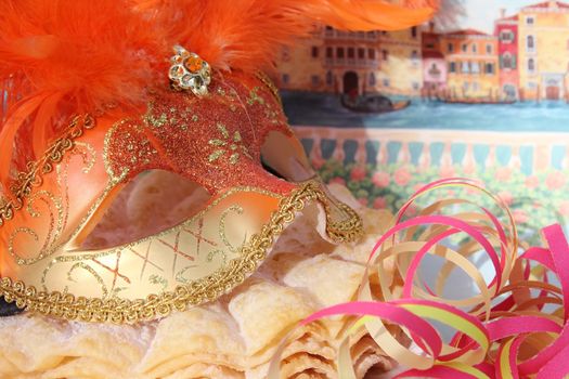 Carnival mask with orange feathers and pancakes