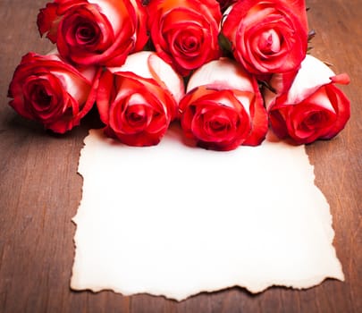 Roses and blank ragged card on the table