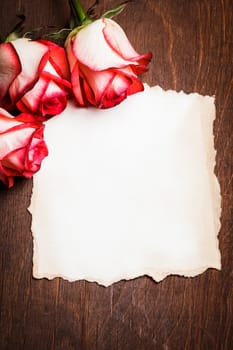 Roses and blank ragged card on the table