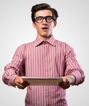 man holds up an electronic tablet, surprised