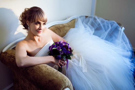 young bride with flowers on the sofa