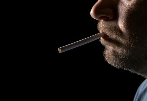 Portrait man smoking cigarette, closeup on black background