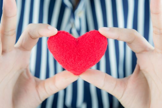 Giving love with hands holding a red heart