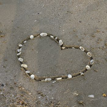 drawing heart on the sand in the beach